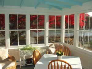 a room with a table and chairs and windows at House on Chase Creek in Shelter Island Heights