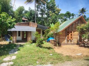 a small house with a green roof at Johns wooden cottages in Sultan Bathery