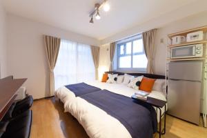a bedroom with a large bed in front of a window at Park Residence Maruyama in Sapporo
