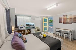 a bedroom with a bed and a desk with a computer at Pacific Motor Inn in Evans Head