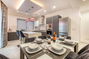 comedor y cocina con mesa y sillas en Birmingham Modern New Highly Furnished 3 BR APT in Gzira-Sliema, en Il-Gżira