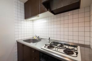 a kitchen with a stove and a sink at Park Residence Maruyama in Sapporo +46 photos