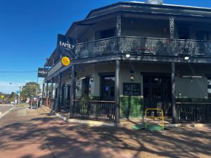 a black building with a balcony on a street at The Family Hotel in Maitland