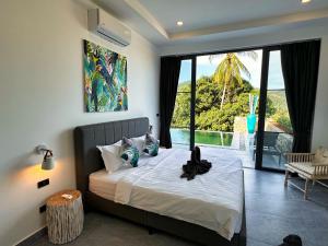 a bedroom with a bed with a view of the ocean at VILLA CAMILLE - SEAVIEW - 4 Bedrooms in Koh Samui 