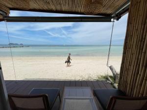 a person walking on a beach with the ocean at Nice Sea Resort in Srithanu +37 photos