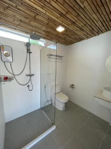 a bathroom with a shower and a toilet at Nice Sea Resort in Srithanu