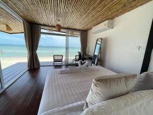 a bedroom with two beds and a view of the beach at Nice Sea Resort in Srithanu