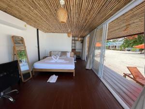 a bedroom with a bed on a wooden floor at Nice Sea Resort in Srithanu