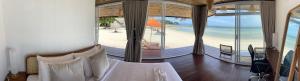 a bedroom with a bed and a view of a beach at Nice Sea Resort in Srithanu