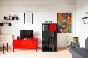 uma sala de estar com um armário vermelho e uma televisão em Bird NEST 2 room apartment em Bucareste