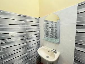La salle de bains est pourvue d'un lavabo et d'un miroir. dans l'établissement RedDoorz @ Porodisa Homestay Palu, à Palu