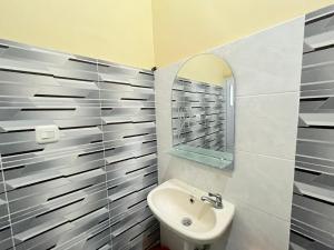 un baño con lavabo y espejo en RedDoorz @ Porodisa Homestay Palu, en Palu