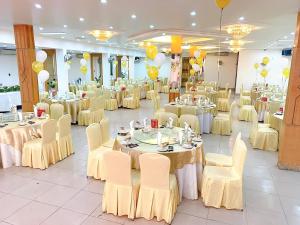 um salão de banquetes com mesas, cadeiras e balões em Khách Sạn Kim Cương Thái Bình em Thái Bình