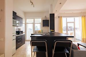 uma cozinha com uma ilha negra num quarto em Bird NEST 2 room apartment em Bucareste