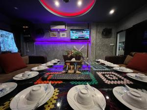 a dining room with a table with white dishes on it at Mountain View Party Hostel in Ban Chong Phli