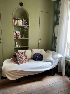 a bed with pillows on it in a room at Cosy Nest in Montmartre in Paris