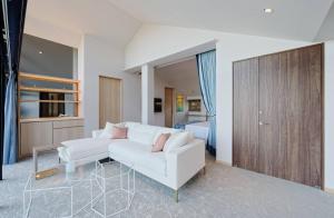 a living room with a white couch and a glass table at TOKIWA M-GARDEN in Mito