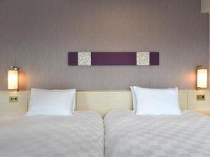 two beds sitting next to each other in a room at Shinjuku Prince Hotel in Tokyo