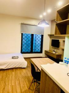 um quarto com uma cama, uma secretária e uma janela em Unique Serviced Apartment em Hanói