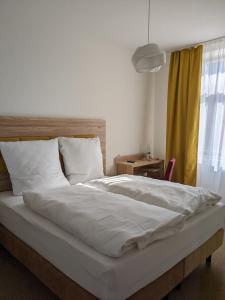 een slaapkamer met een groot bed met witte lakens en een raam bij Gasthaus Mandelhof in Neustadt an der Weinstraße