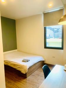 um pequeno quarto com uma cama e uma janela em Unique Serviced Apartment em Hanói