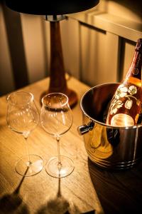 tres copas de vino en una mesa con una botella de champán en The Boutique Hotel Dsignio, en Ladenburg