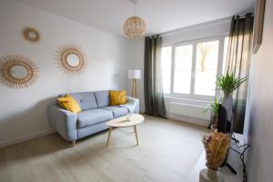 sala de estar con sofá azul y mesa en L'olivier - Appartement moderne et chaleureux - TRAM et PARC, en Grenoble
