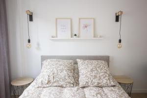 1 dormitorio con 1 cama con 2 almohadas y estante en L'olivier - Appartement moderne et chaleureux - TRAM et PARC, en Grenoble