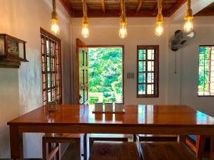 BarasL'Astrolabe - Havre de Paix的带窗户的房间里有一张大木桌