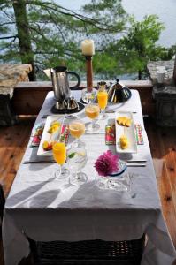 a table with glasses of orange juice and food on it at Gîte et Atelier de L'Artiste Peintre Paysagiste Canadien Gordon Harrison in Sainte-Marguerite
