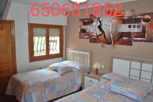 sypialnia z 2 łóżkami i zegarem na ścianie w obiekcie Apartamento Rural Lago Ercina w mieście Cangas de Onís