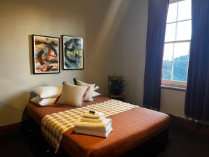 ein Schlafzimmer mit einem Bett mit Handtüchern darauf in der Unterkunft The Family Hotel in Maitland