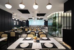 a dining room with tables and chairs and lights at Empathy Hotel - Guangzhou East Railway Station Tianhe Sports Center in Guangzhou