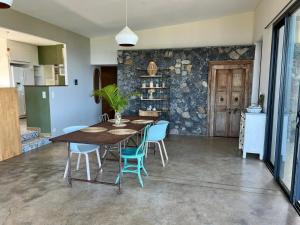 une salle à manger avec une table en bois et des chaises bleues dans l'établissement La Villa Bleue - Villa d'architecte - Jacuzzi, à Saint-Paul