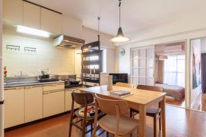 Una cocina y un comedor con mesa y sillas. en Chatelet Nishi-Oi, en Tokio