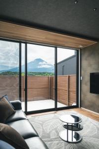 a living room with a couch and a view of a mountain at Fuji no Sato Alibio in Fujikawaguchiko