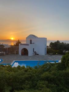 una vista de un edificio con una puesta de sol en el fondo en Iliopetra Studios, en Chrissi Akti