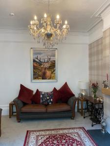 a living room with a couch and a chandelier at Heathbank House B&B in Matlock Bank