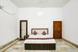 1 dormitorio con 1 cama grande en una habitación en FabExpress Prashansa Palace, en Varanasi