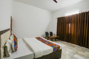 1 dormitorio con 1 cama en una habitación con ventana en FabExpress Prashansa Palace, en Varanasi