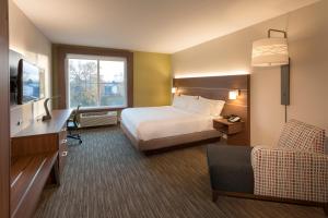 a hotel room with a bed and a television at Holiday Inn Express & Suites - Seattle South - Tukwila by IHG in Tukwila