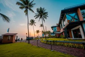 een groep gebouwen en palmbomen op het strand bij ANANSA BOUTIQUE HOTEL by The Kannur Club in Kannur