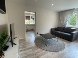 ein Wohnzimmer mit einem Sofa und einem Tisch in der Unterkunft Expansive One Bedroom Gem in a Peaceful Locale in Riga
