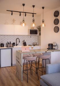 a kitchen with a island with bar stools at Golden Beach / De Shalit in Herzliyya B