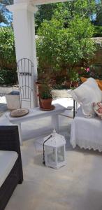 een patio met een witte tafel en stoelen en planten bij Trullo Donna Caterina in Ceglie Messapica