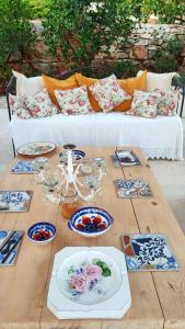a wooden table with plates and dishes on it with a couch at Trullo Donna Caterina in Ceglie Messapica +69 photos