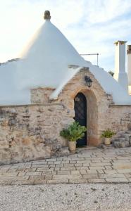 a stone building with a snow covered roof at Trullo Donna Caterina in Ceglie Messapica