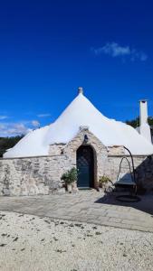 a stone building with a white roof at Trullo Donna Caterina in Ceglie Messapica