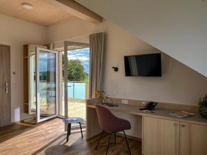 Berg bei RavensburgにあるGasthof Hasenのデスク、椅子、テレビが備わる客室です。