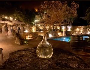 un vase en verre avec un arbre à côté d'une piscine dans l'établissement Résidence de Luxe 4 étoiles à Pietralba, 4 logements piscine chauffée BALAGNE, à Pietralba
